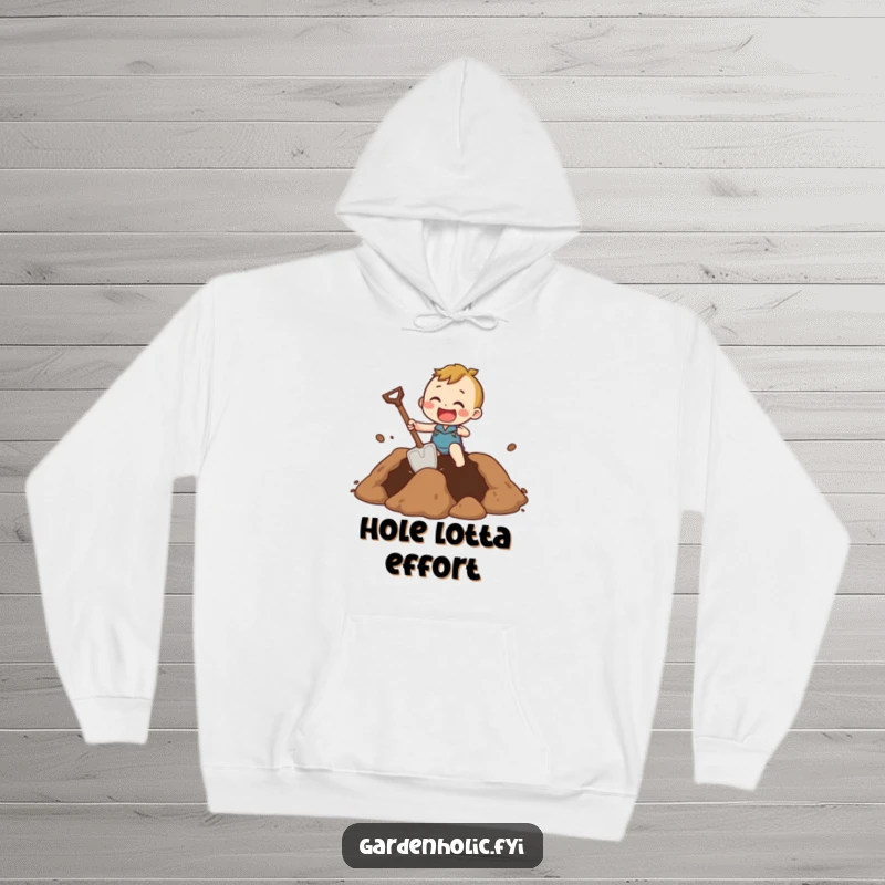 Funny Hoodie of a character excitedly digging a massive hole using a comically small shovel, representing grand endeavors.